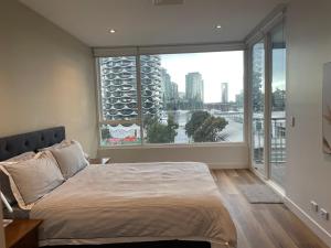 墨尔本Docklands Luxury Penthouse Right Above The District Docklands的一间卧室设有一张床和一个大窗户