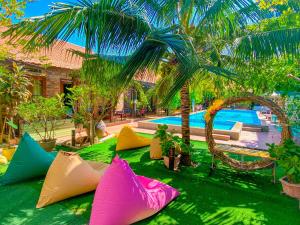美奈五月酒店的一群五颜六色的枕头坐在游泳池附近的草地上