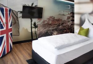 WaidhofenSOB Hotel by WMM Hotels的一间卧室配有一张床,墙上配有电视