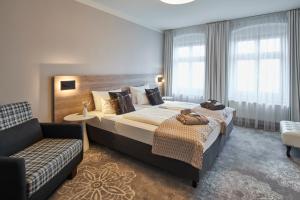 格尔利茨Hotel Via Regia - VIAs-Hotels的酒店客房设有一张大床和一张沙发。