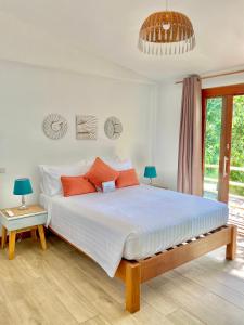 Haad PleayleamKalulushi Bungalows的卧室配有带橙色枕头的大型白色床