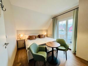 阿伦斯霍普Haus Nordlicht的一间卧室配有一张床、两把椅子和一张桌子