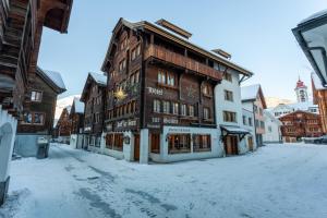 安德马特Sonne Andermatt Swiss Quality Hotel的地面上积雪的街道上的建筑