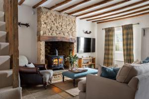 AdlestropCharming 17th Century Cotswold Cottage的客厅设有壁炉和沙发。