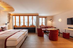 安德马特Sonne Andermatt Swiss Quality Hotel的酒店客房设有一张大床和一间客厅。