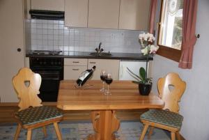 马洛亚Pra d'Sura 104的厨房配有一张木桌和两杯葡萄酒