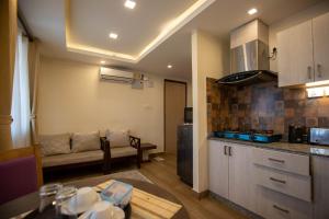 迦瓦拉科尔Sarovar Residency Serviced Apartment Hotel的厨房以及带沙发和桌子的客厅。