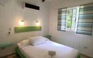 蒙特苏马Boho lodge Montezuma l&l的卧室配有白色的床和窗户。