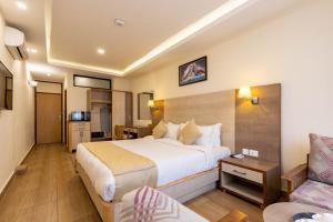 迦瓦拉科尔Sarovar Residency Serviced Apartment Hotel的酒店客房设有一张大床和一张沙发。