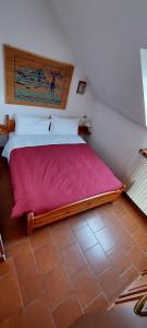 布勒伊-切尔维尼亚维尼亚迪尤公寓式酒店的一间卧室配有一张带粉红色床单的大床