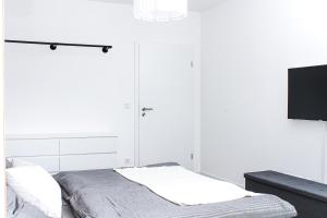 施瓦岑贝格Panorama Schwarzenberg的一间白色卧室,配有床和电视