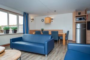 埃尔堡Veluwe Strandbad Elburg的客厅配有蓝色的沙发和桌子
