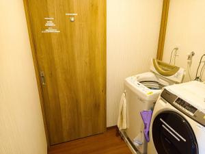 高松Guest House Ihatov - Vacation STAY 22122v的一间带洗衣机和木门的厨房