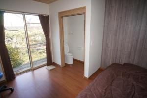高松Guest House Ihatov - Vacation STAY 22122v的一间卧室配有一张床,一扇门通往浴室