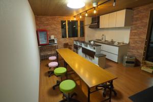 高松Guest House Ihatov - Vacation STAY 00941v的厨房配有木桌和绿色椅子