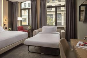 纽约NH Collection New York Madison Avenue的酒店客房设有两张床和窗户。
