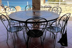 Calheta Do MaioVilla GÊMEO vue mer, piscine accès privé plage的一张黑桌子和椅子,一张桌子,享有海景