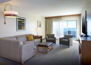 大洋城Hyatt Place Ocean City Oceanfront的客厅配有沙发、椅子和电视