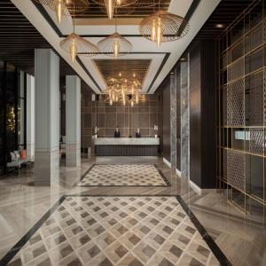 巴东Hotel Santika Premiere Padang的酒店大堂设有瓷砖地板和吊灯