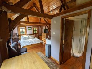 布罗肯赫斯特Cabin in the Forest的一间带一张床的卧室,位于带木制天花板的房间内