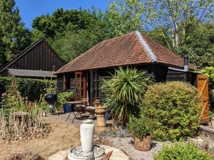 布罗肯赫斯特Cabin in the Forest的花园中带屋顶的小房子