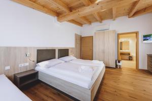 滨湖采尔Appartements Sulzer by we rent, SUMMERCARD INCLUDED的卧室配有一张白色大床,铺有木地板