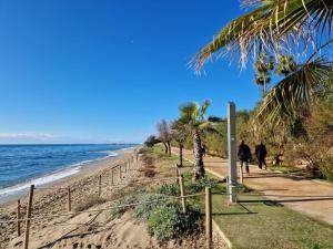 马贝拉Villa Costa Marbella的天气晴朗时,人们沿着海滩散步