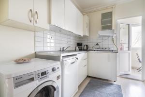 伊斯坦布尔Modern Flat with Balcony on Bagdat Street的白色的厨房配有洗衣机和烘干机