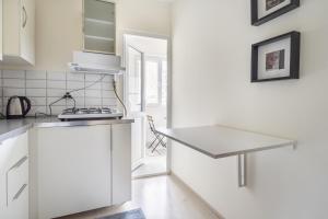 伊斯坦布尔Modern Flat with Balcony on Bagdat Street的白色的厨房配有柜台和桌子