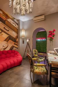 罗马纳沃纳色彩酒店的客厅配有红色的沙发和桌子