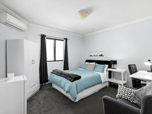 悉尼Sunny Rooms Mascot的一间卧室配有一张床和一张沙发