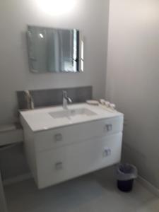 Urville-Nacquevillereve capel的白色的浴室设有水槽和镜子