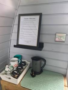 DerwenDelightful Camping Pod in Snowdonia, North Wales.的一张桌子,上面有咖啡壶和标志