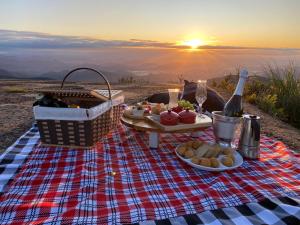 圣若泽-杜斯奥森蒂斯Morada Alto Das Nuvens的野餐毯,带餐桌,有食物和日落