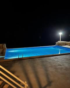 Calheta Do MaioVilla GÊMEO vue mer, piscine accès privé plage的夜间蓝色游泳池,有街灯
