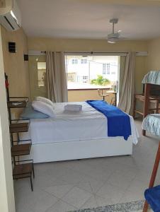 布希奥斯Andorinhas Suites的卧室设有一张白色大床和一扇窗户。