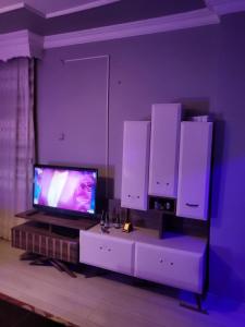 埃尔祖鲁姆Erzurum DAMAK GRUP的一间带电视和一些白色橱柜的客厅