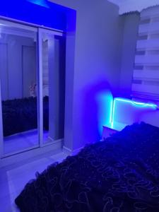 埃尔祖鲁姆Erzurum DAMAK GRUP的一间卧室配有一张床和一个带紫色灯的窗户