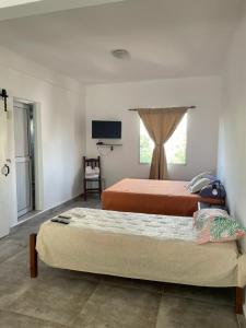 科连特斯La Escala ll的一间卧室配有两张床和一台平面电视