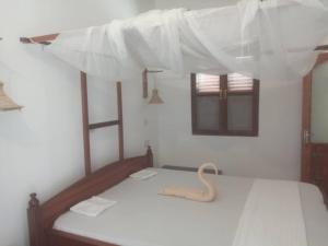 江比阿Iddi House的一间卧室配有两张带白色床单的床
