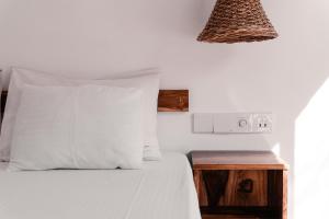迪克韦勒Summer Time Hiriketiya的一张带白色枕头和木床头柜的床