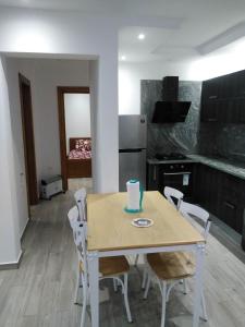 乌姆苏克Résidence Inès Djerba Appartement de Luxe的厨房配有桌椅和蛋糕