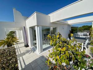 拉格朗德默特Le Swing N01 toit terrasse的白色的房子,设有种有椅子和植物的庭院