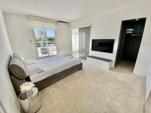 拉格朗德默特Le Swing N01 toit terrasse的白色卧室设有一张大床和电视。