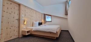 萨姆瑙恩夏萨城堡休闲水疗酒店的一间卧室设有一张床和木墙