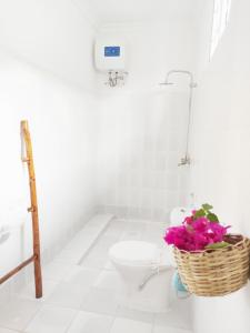 南威MaNa Nungwi的一间带卫生间的浴室和一篮鲜花