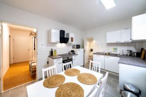 林特尔恩Modernisiertes Altbau 3-Zi Apartment的厨房配有白色橱柜和桌椅