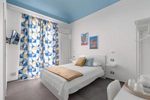 巴勒莫MolteVolte Rooms的白色卧室设有床铺和蓝色天花板
