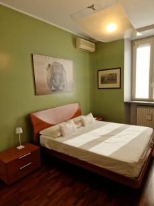 米兰Cozy flat mins walk to Navigli and metro Porta Genova的一间卧室设有一张带绿色墙壁的大床