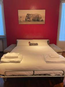 米兰Cozy flat mins walk to Navigli and metro Porta Genova的红色墙壁的房间里一张床位